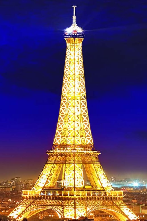 The Eiffel Tower illuminated at night above Paris